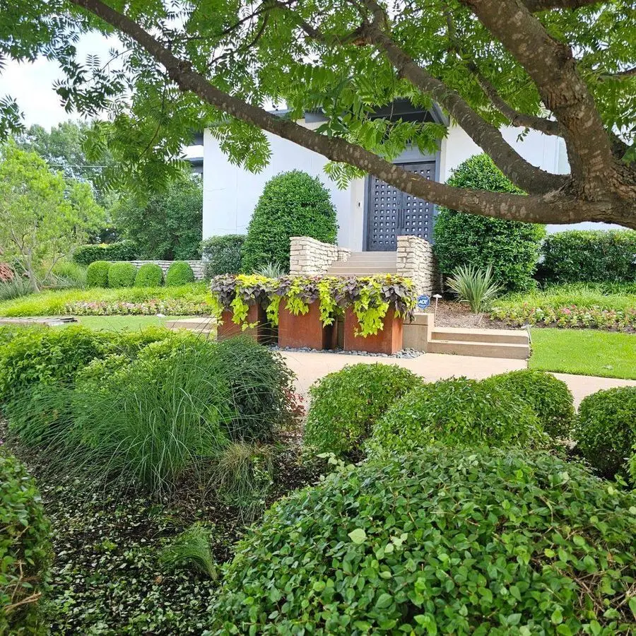 Modern home entry with ornamental grasses and copper planters
