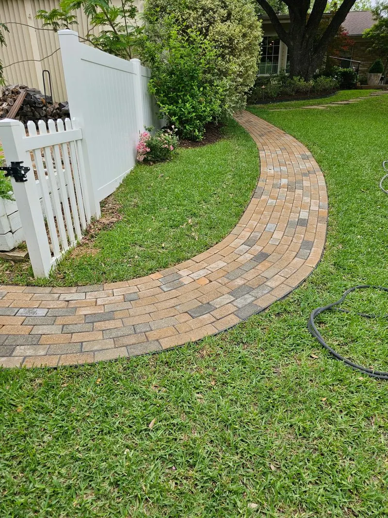 Curved paver walkway through green lawn